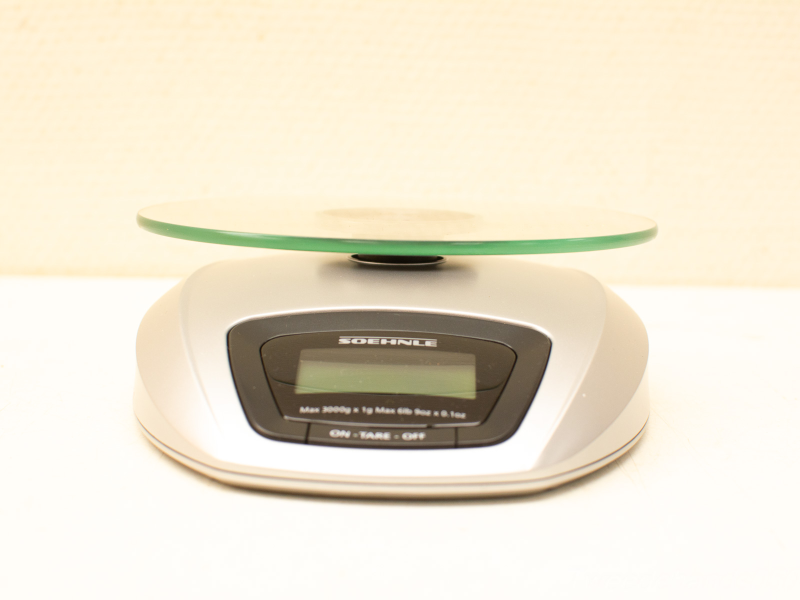 Sleek metallic digital kitchen scale with glass platform, 3000g capacity, perfect for precise cooking.