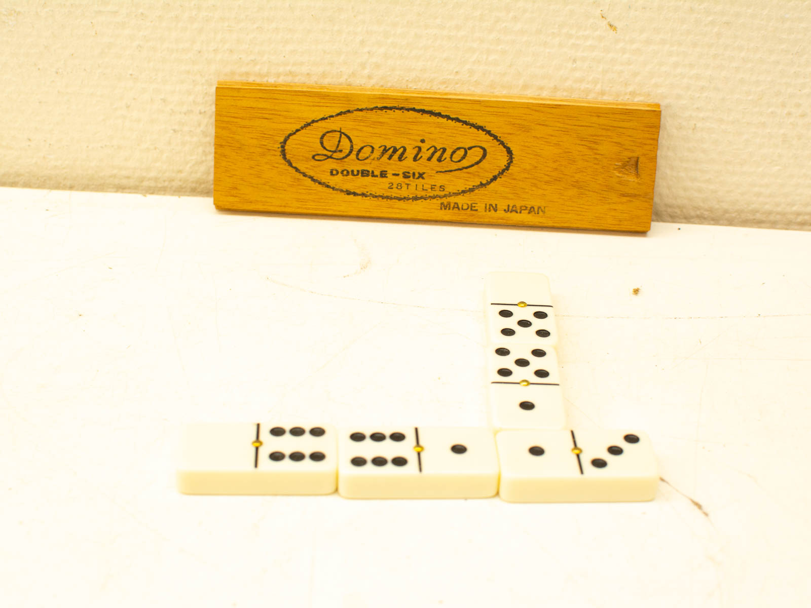 Vintage domino set with 28 tiles in elegant wooden box, perfect for game nights.