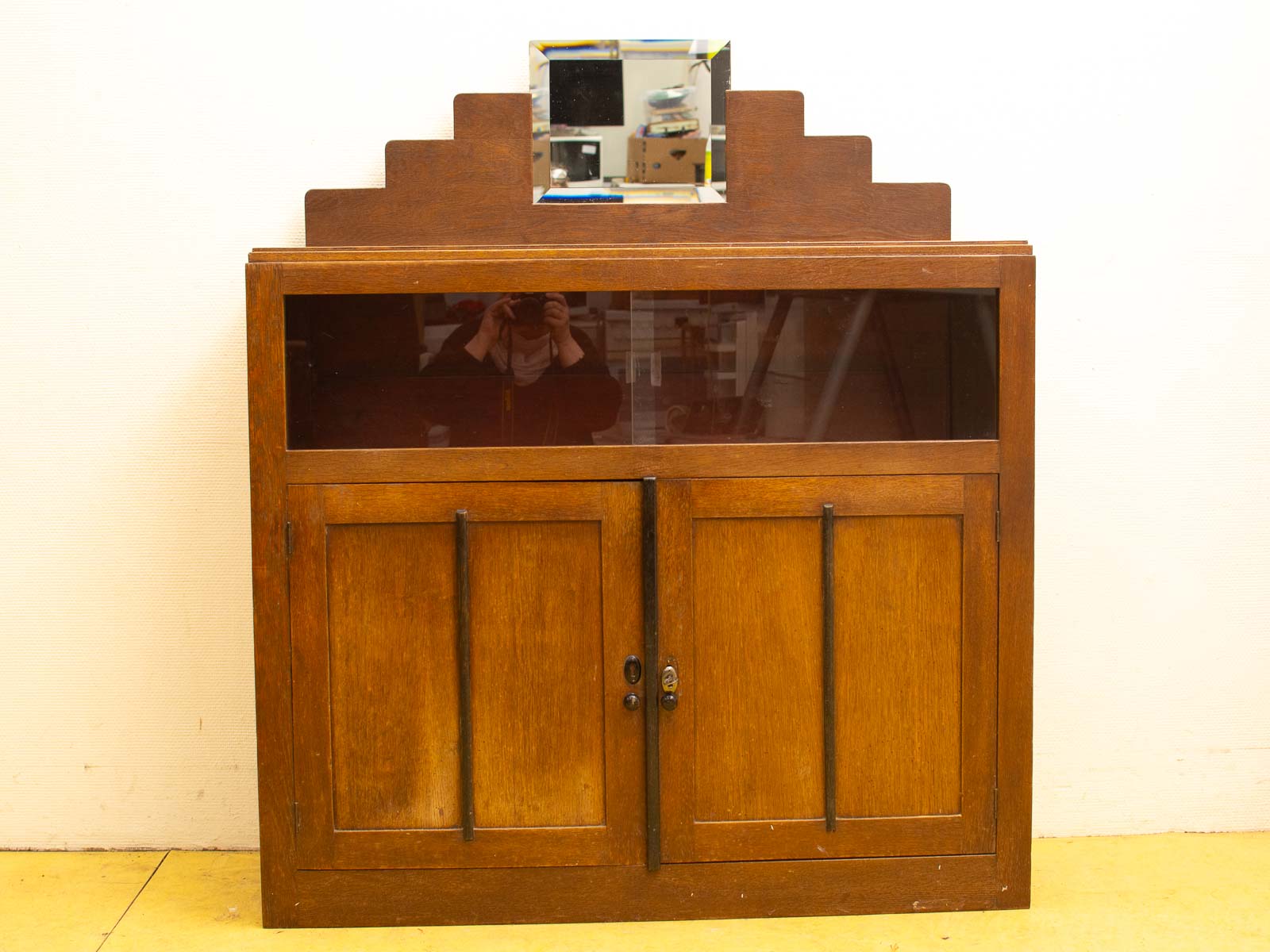 Elegant vintage wooden cabinet with glass panel and mirror, showcasing fine craftsmanship and classic design.