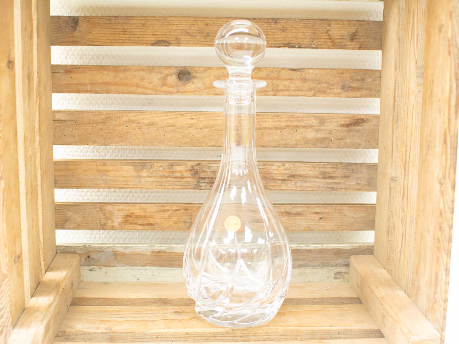 Elegant glass decanter on a rustic wooden crate, perfect for serving fine wines.