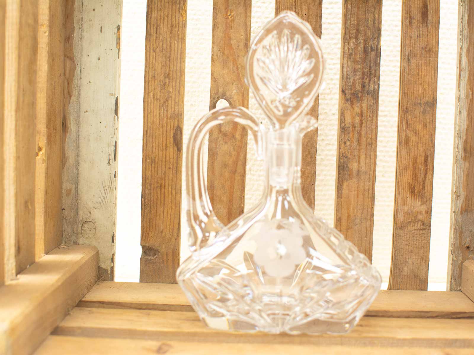 Elegant glass decanter on rustic wood, showcasing fine craftsmanship and sophisticated home decor.