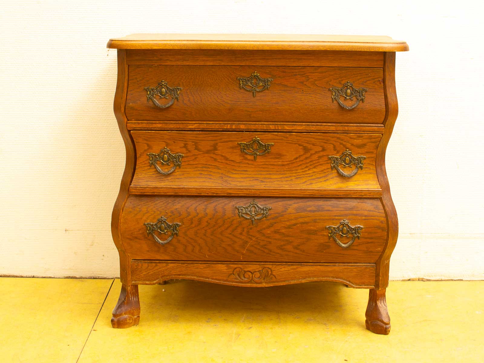 Elegant vintage wooden chest of drawers with brass handles and curved legs for timeless charm.