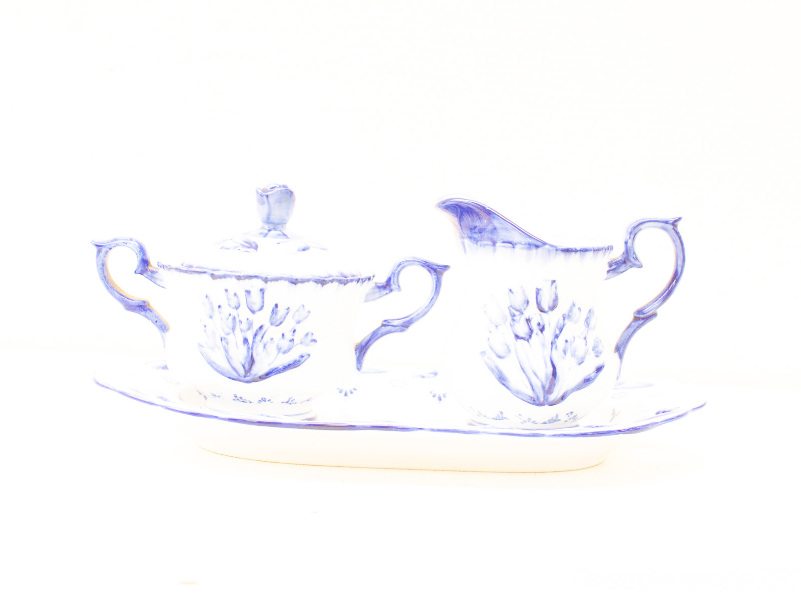 Elegant blue and white porcelain sugar bowl and cream jug set on a stylish tray.