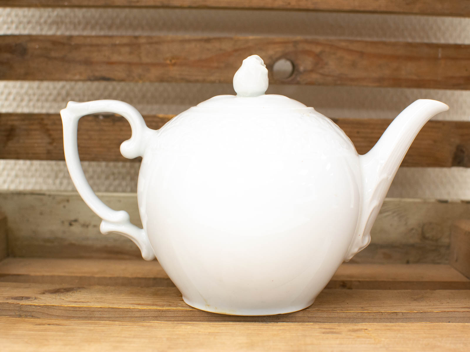 Elegant white porcelain teapot with whimsical bird lid, perfect for tea gatherings and decor.