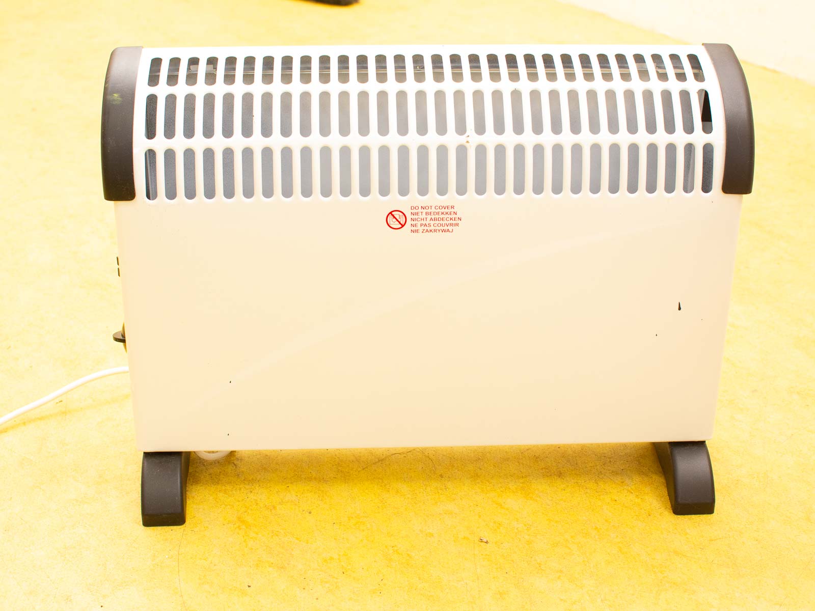 Stylish white electric space heater with ventilation and safety label, perfect for indoor heating.