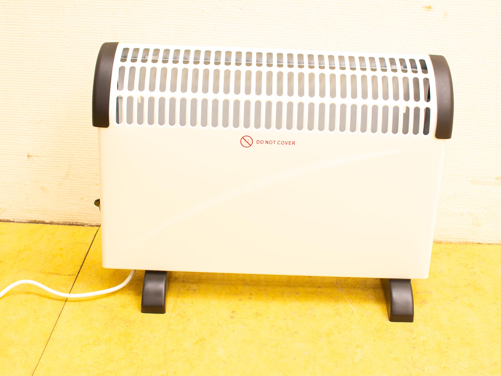 Sleek white and black indoor electric heater with safety vents for efficient warmth.