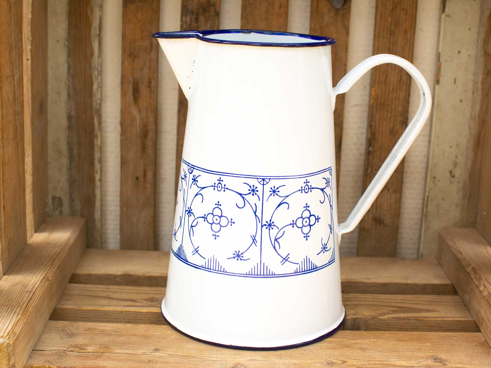 Elegant white ceramic pitcher with blue floral patterns, perfect for rustic home decor.