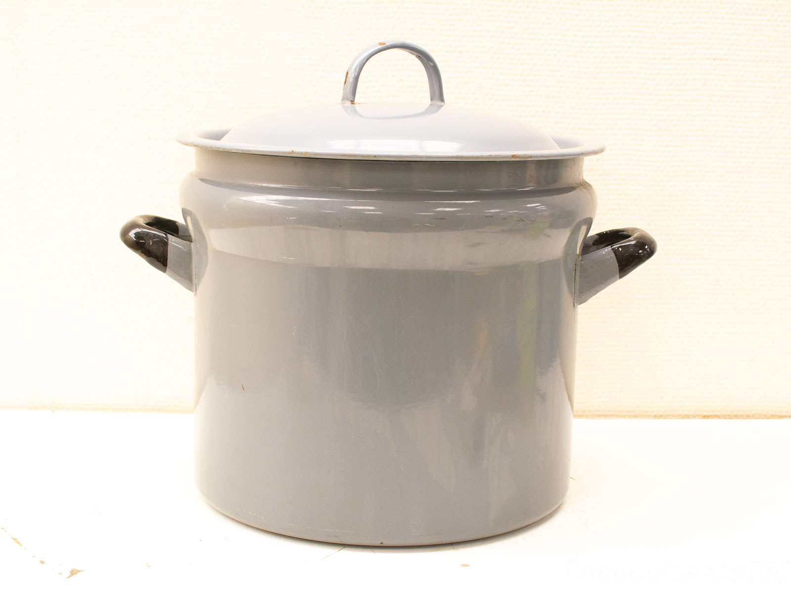 Stylish gray enameled cooking pot with lid and handles, perfect for any kitchen.