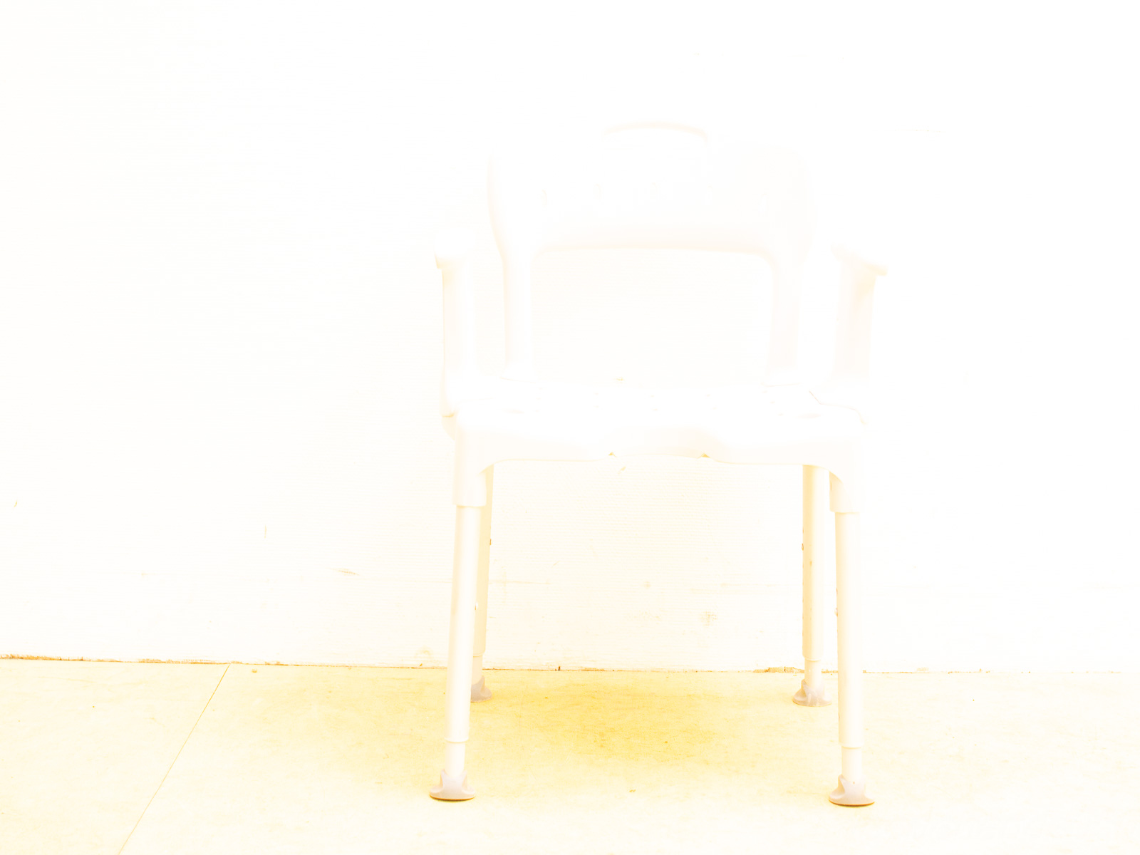 Vintage white plastic chair against a bright background, showcasing simplicity and ergonomic design.