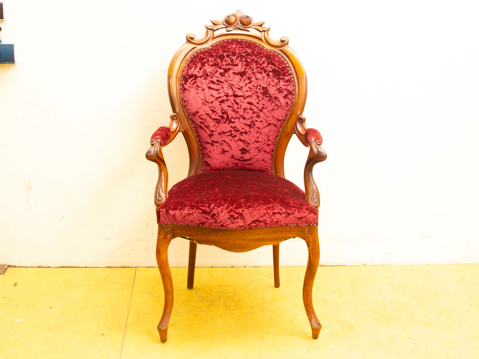 Vintage Victorian chair in deep red, featuring ornate carvings and luxurious upholstery for elegant decor.