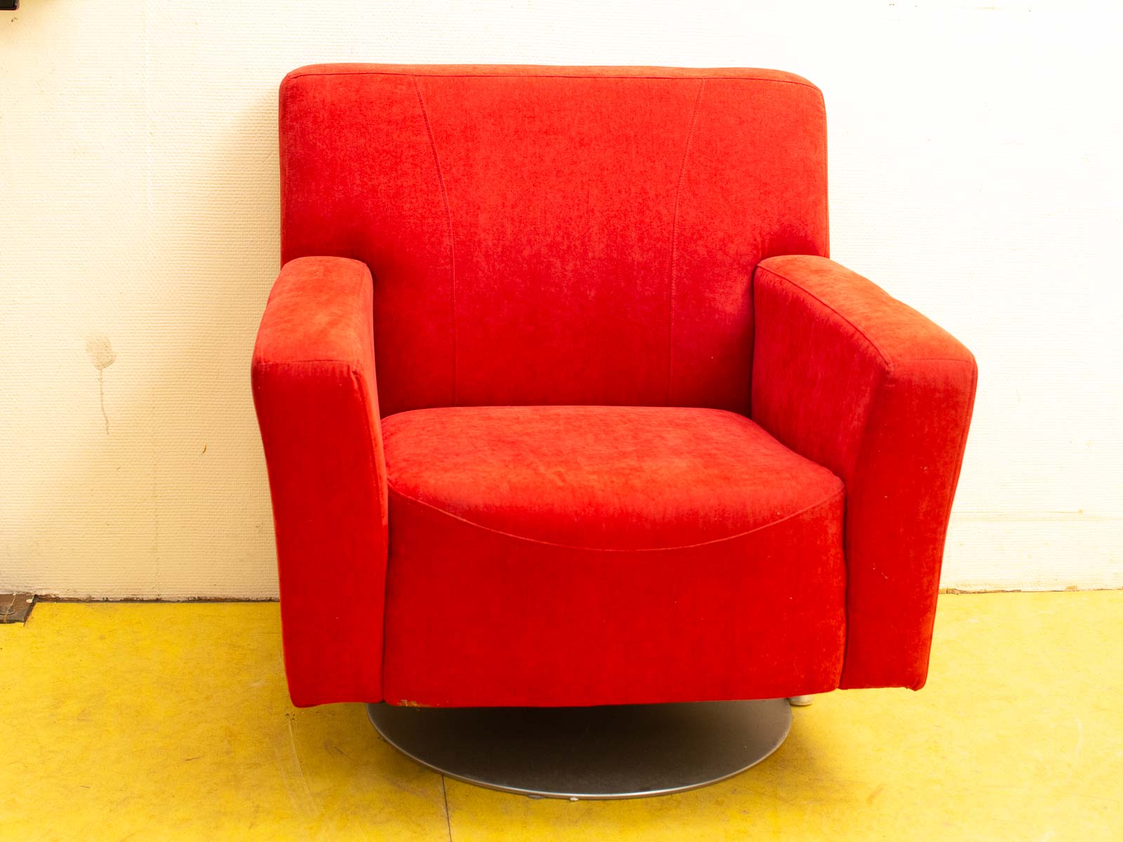 Vibrant red swivel armchair with plush upholstery, perfect for stylish and comfortable living spaces.