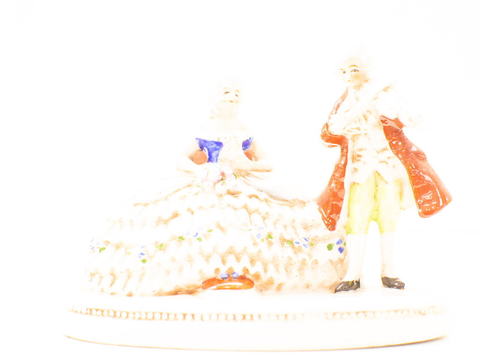 Charming vintage couple figurine in historical attire, capturing romance and nostalgia beautifully.