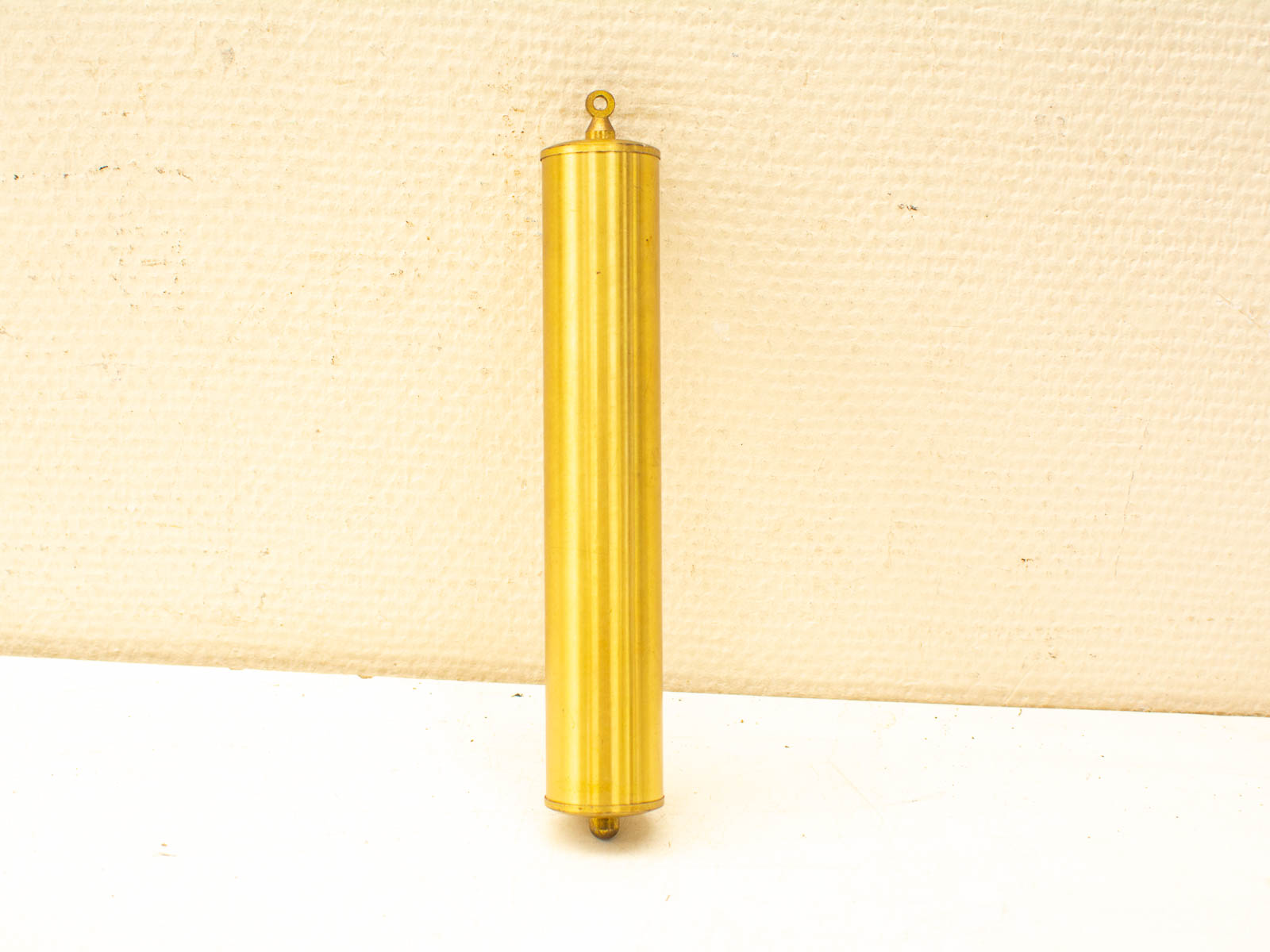 Elegant vintage gold cylinder with grooves, loop for hanging; perfect for decor or functionality.