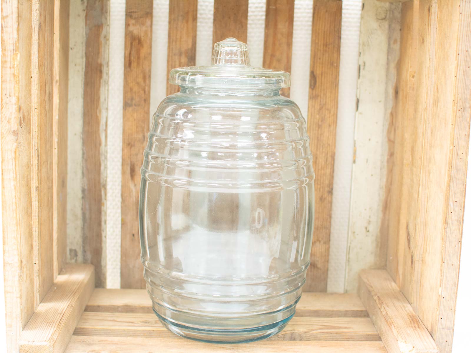 Elegant glass jar on rustic wooden crate, perfect for vintage decoration and stylish storage.