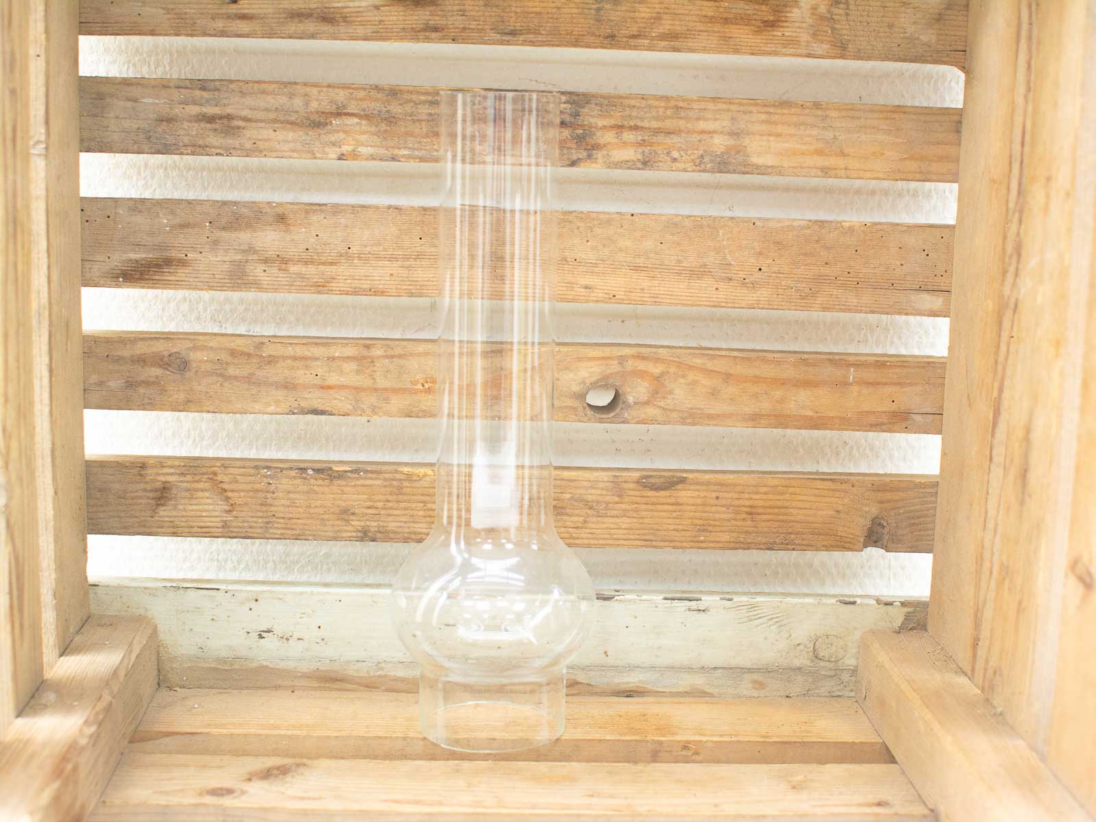 Clear glass laboratory flask on rustic wooden background, combining science and natural beauty.