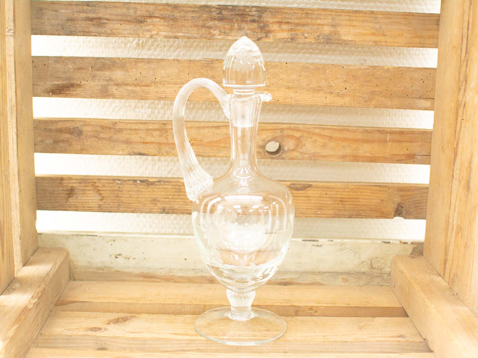 Elegant glass decanter with floral motifs, perfect for serving drinks or as decor.