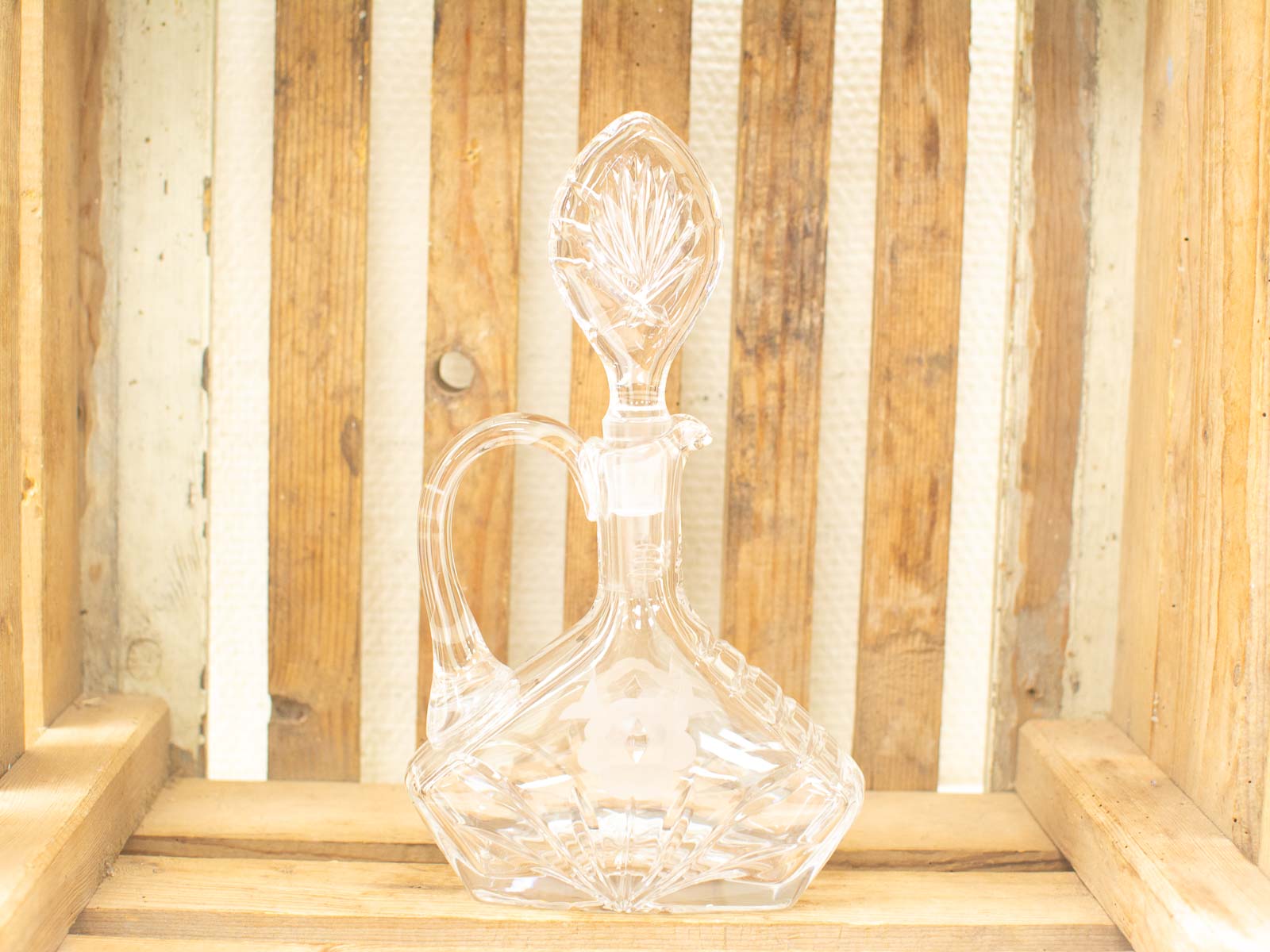 Elegant vintage glass decanter on rustic wood, perfect for wine or home decor.