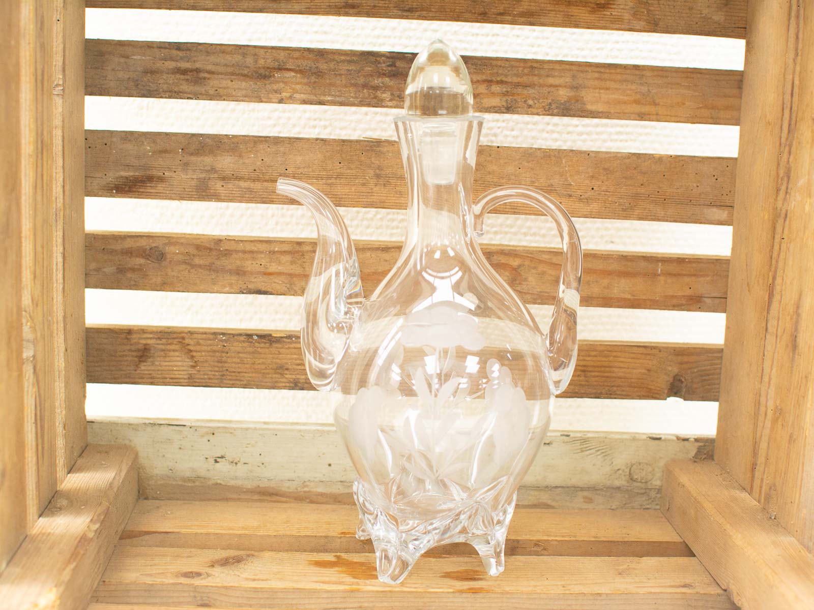 Elegant glass decanter with intricate etched floral designs, perfect for sophisticated decor.