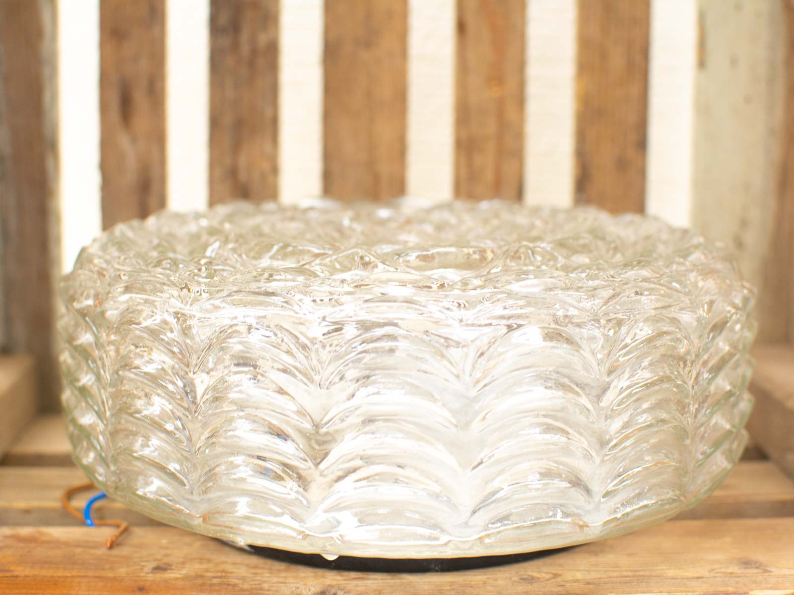 Elegant vintage glass dish with embossed design on rustic wood, perfect for decor or serving.