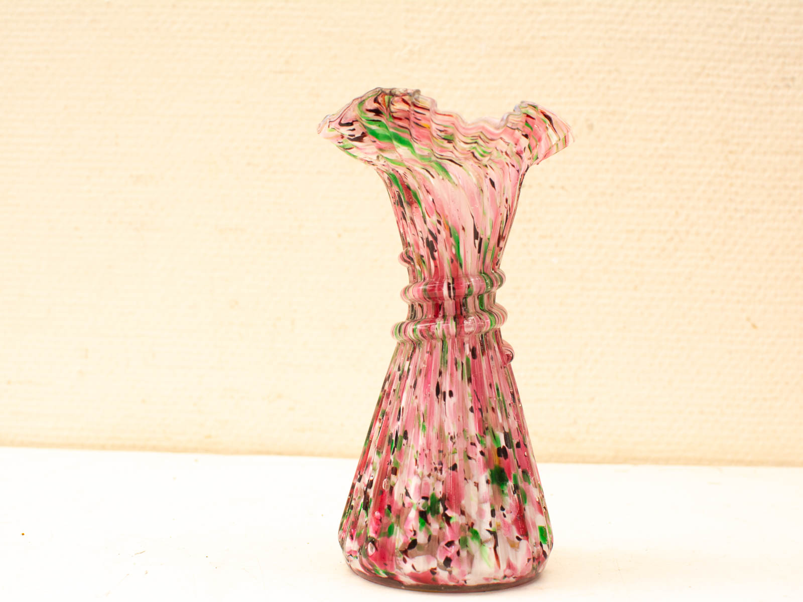 Elegant vintage glass vase with vibrant pink and green design, perfect for decor or flowers.