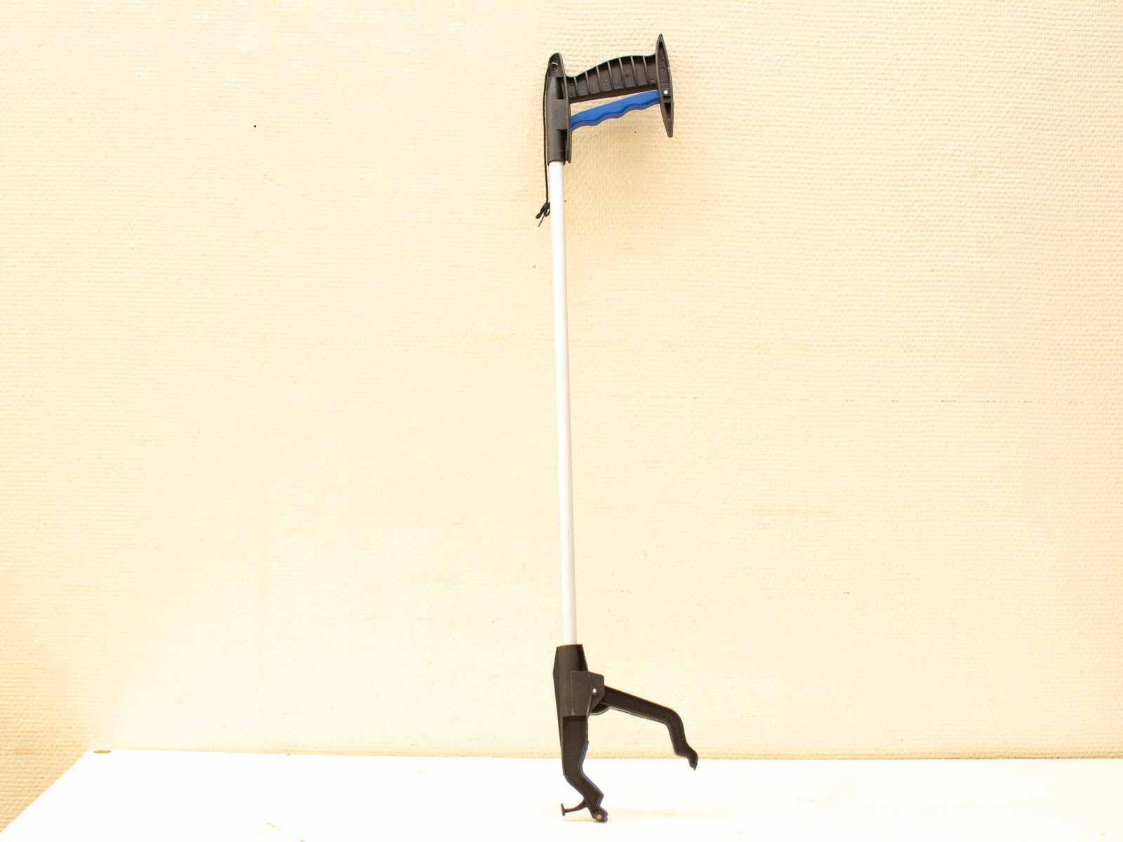 Ergonomic silver grabber with comfortable handle and secure claw for easy reaching and accessibility.