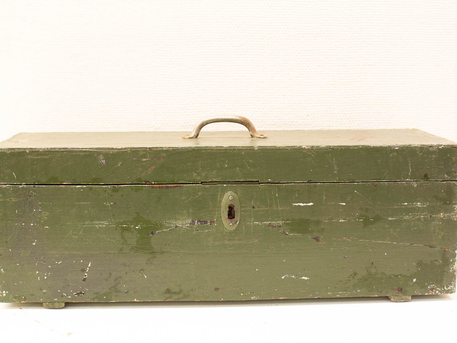 Rustic vintage green wooden toolbox with metal handle, keyhole, and weathered charm.