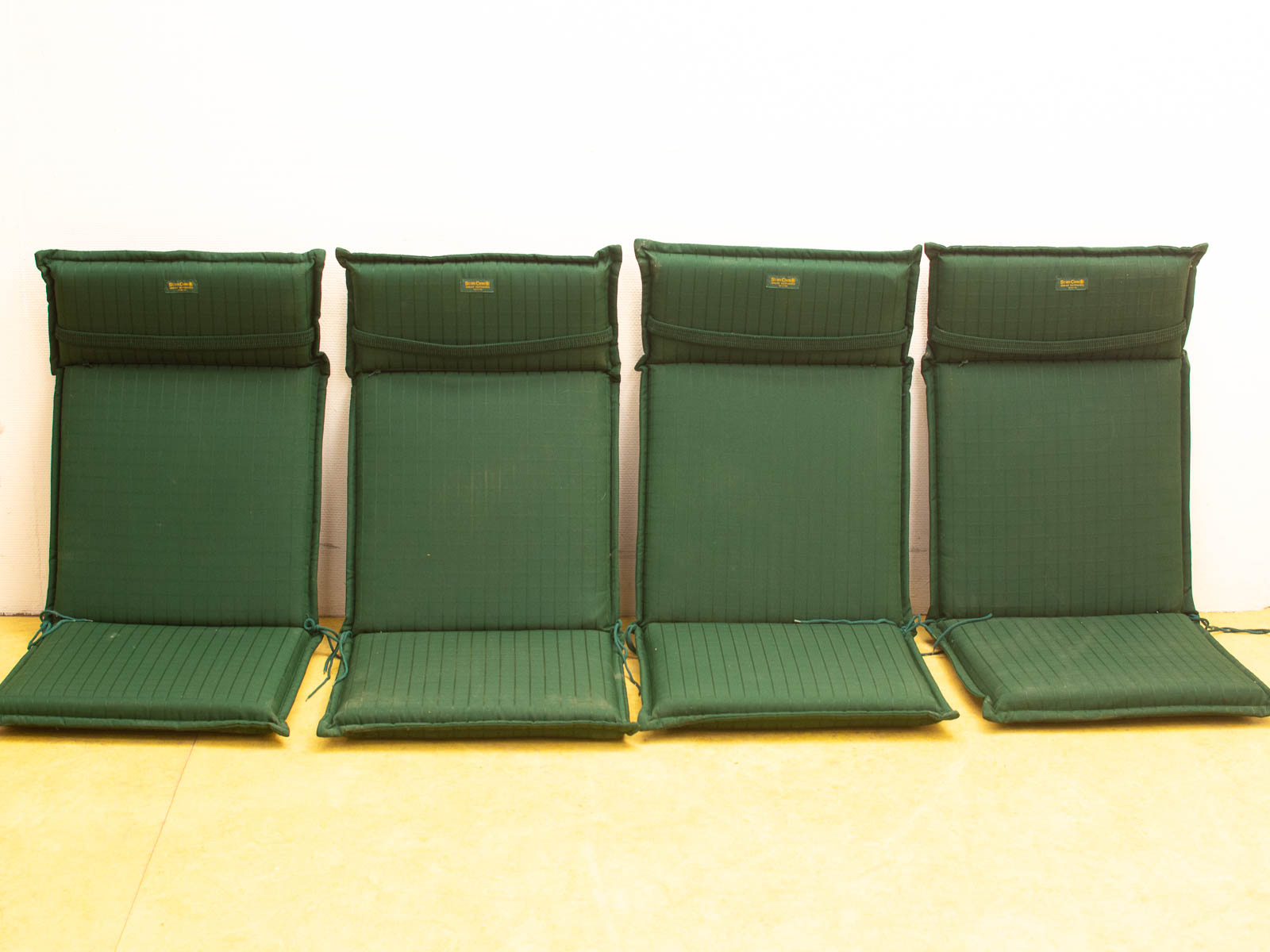 Stylish green seating cushions with high backrests, perfect for indoor and outdoor comfort.