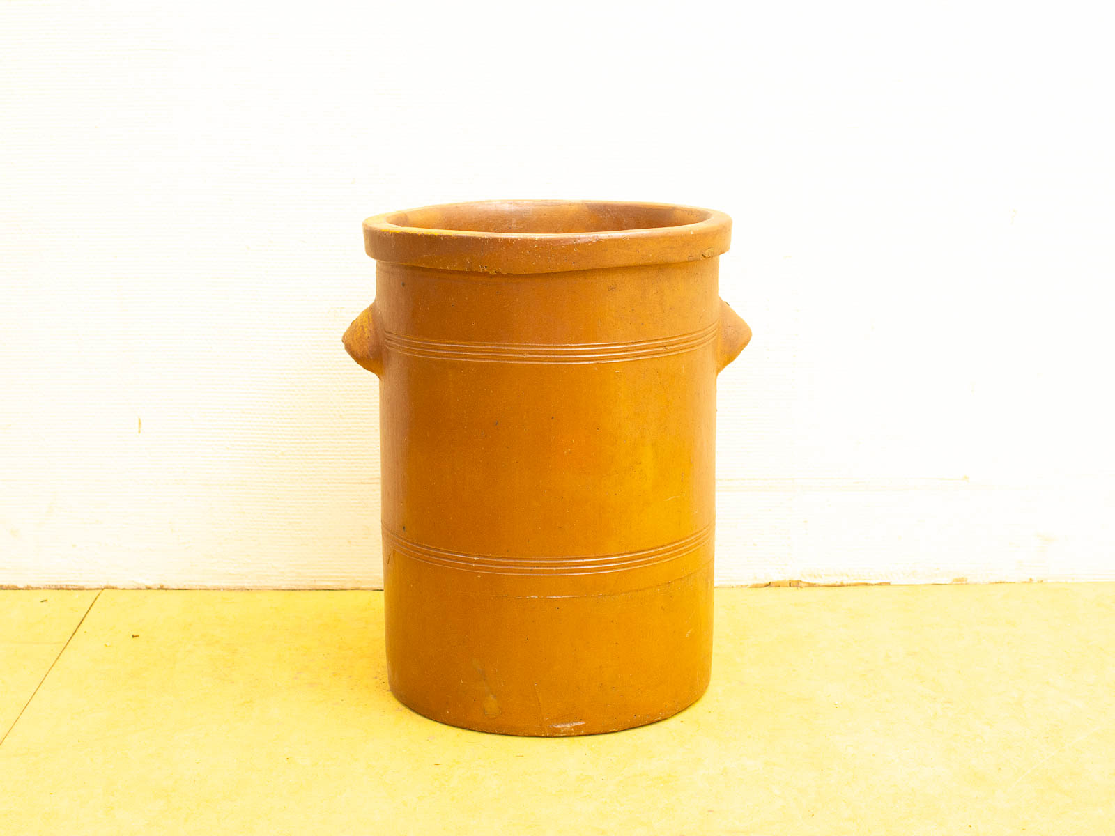 Rustic vintage terracotta pot with handles, perfect for decorative display or practical storage.