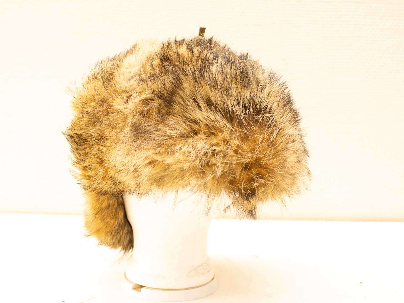 Vintage brown fur hat with ear flaps, combining warmth and style for winter outings.