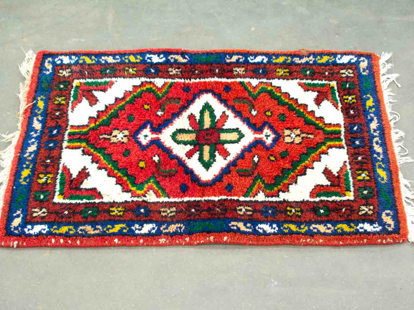 Vibrant vintage area rug with geometric patterns and floral designs, showcasing traditional craftsmanship.