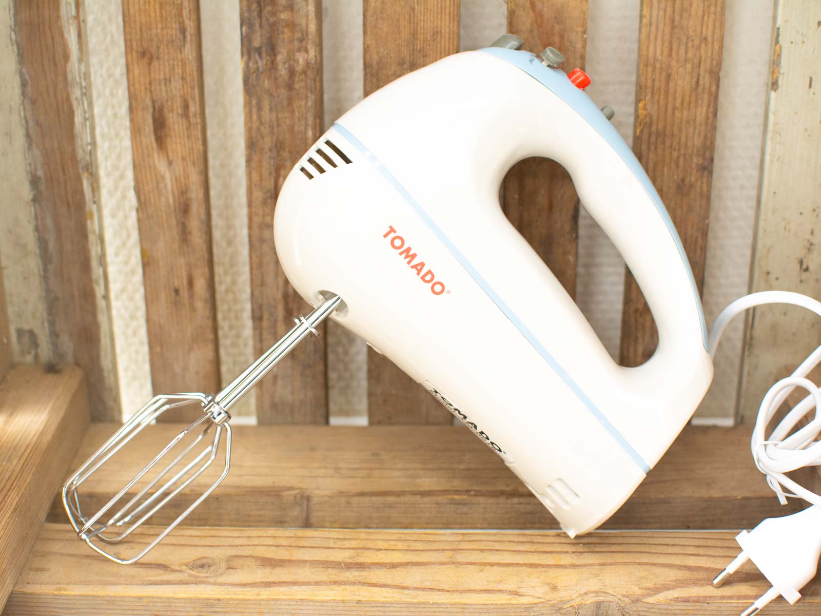 TOMADO electric mixer in white and blue, perfect for blending in a rustic kitchen setting.