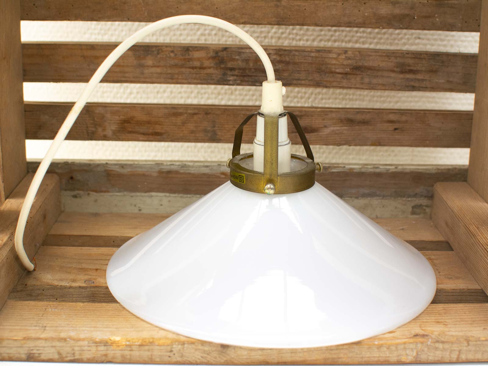 Elegant vintage pendant lamp with glossy white shade and brass mount, perfect for cozy spaces.