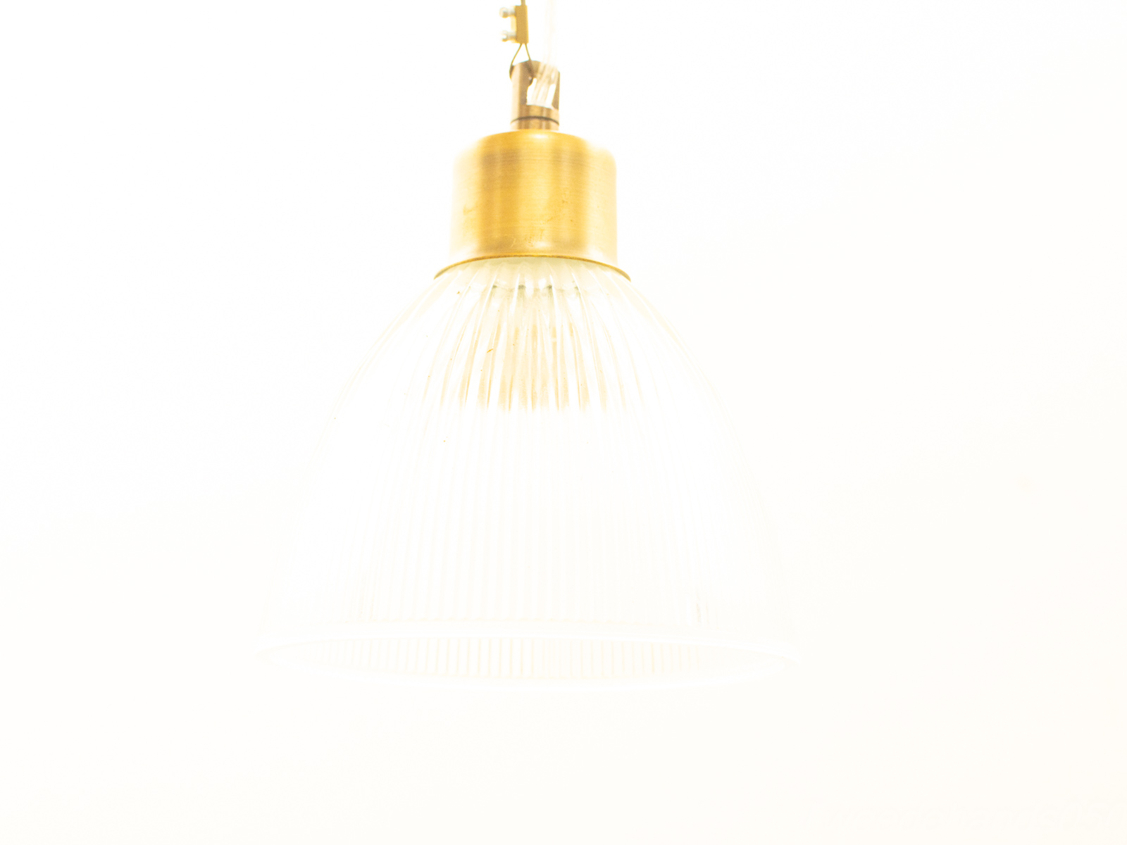 Elegant vintage pendant light with ribbed glass shade and warm brass finish for timeless charm.