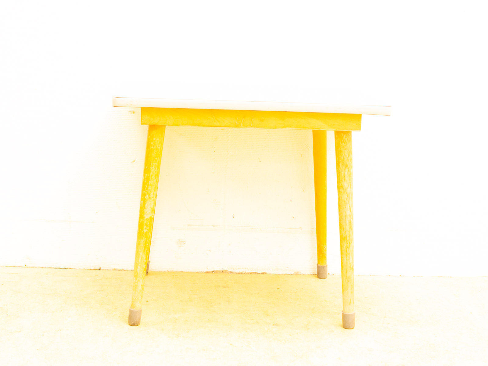 Bright yellow table with white top, perfect for vintage style and cheerful decor.