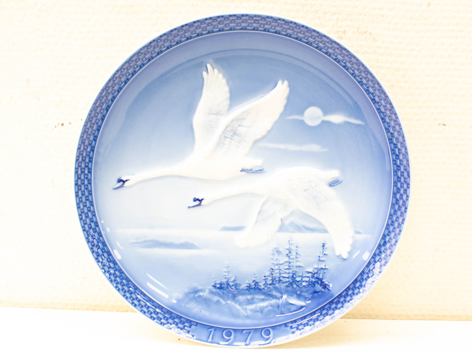 Elegant 1979 decorative plate with swans, serene blue background, and intricate woven rim.