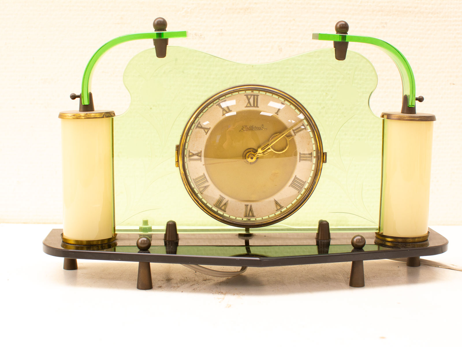 Elegant vintage clock with a golden face and green panels, perfect for decor and timekeeping.