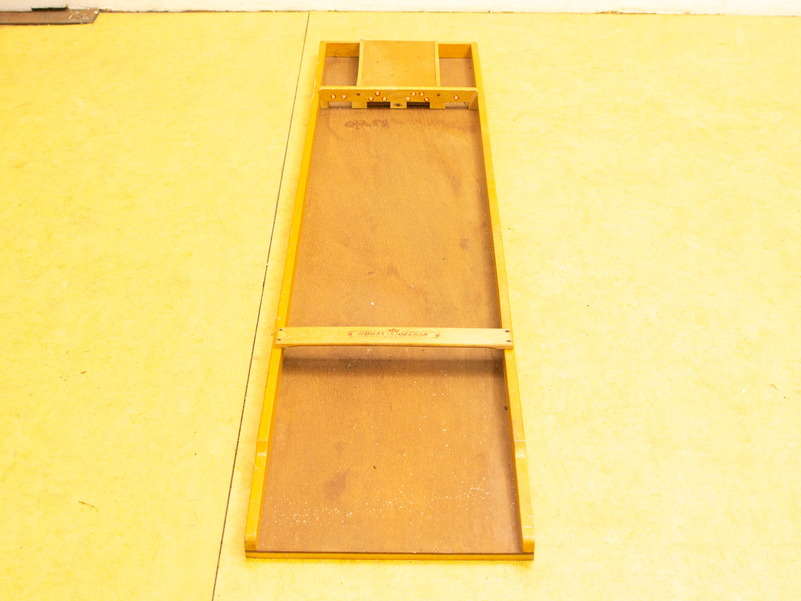 Light brown wooden workspace with yellow frame, storage cutout, and central support strip.