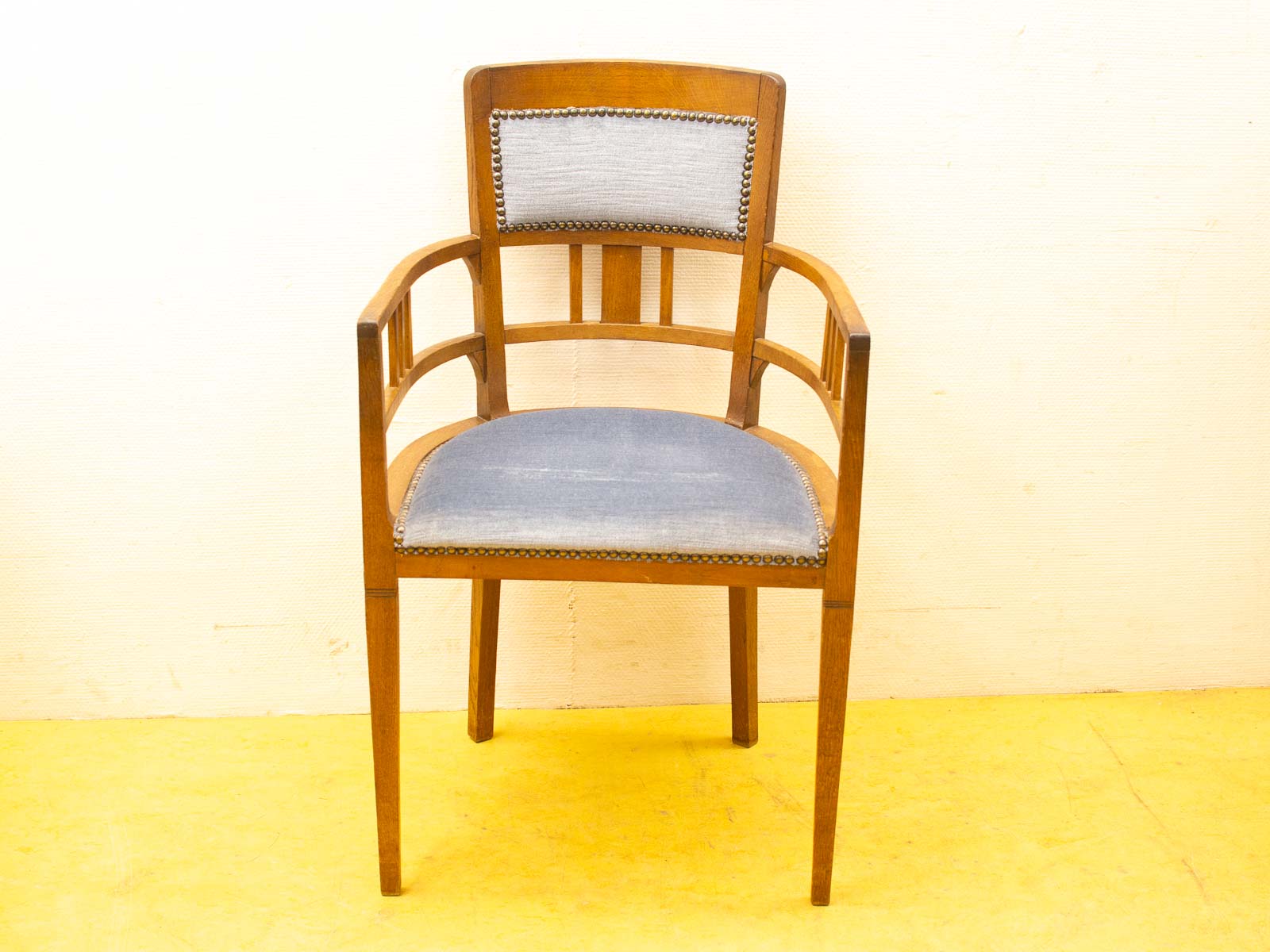 Elegant vintage wooden armchair with blue upholstery and stylish studded trim for cozy spaces.