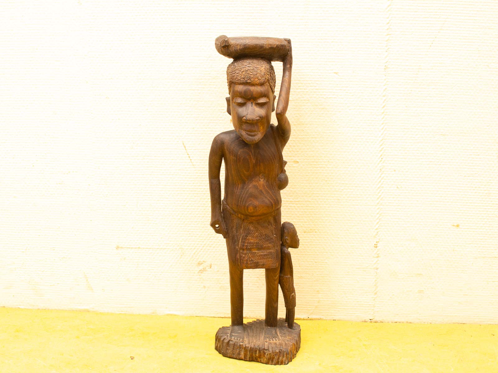 Wooden statue symbolizing kinship and wisdom, featuring a standing figure and child companion.