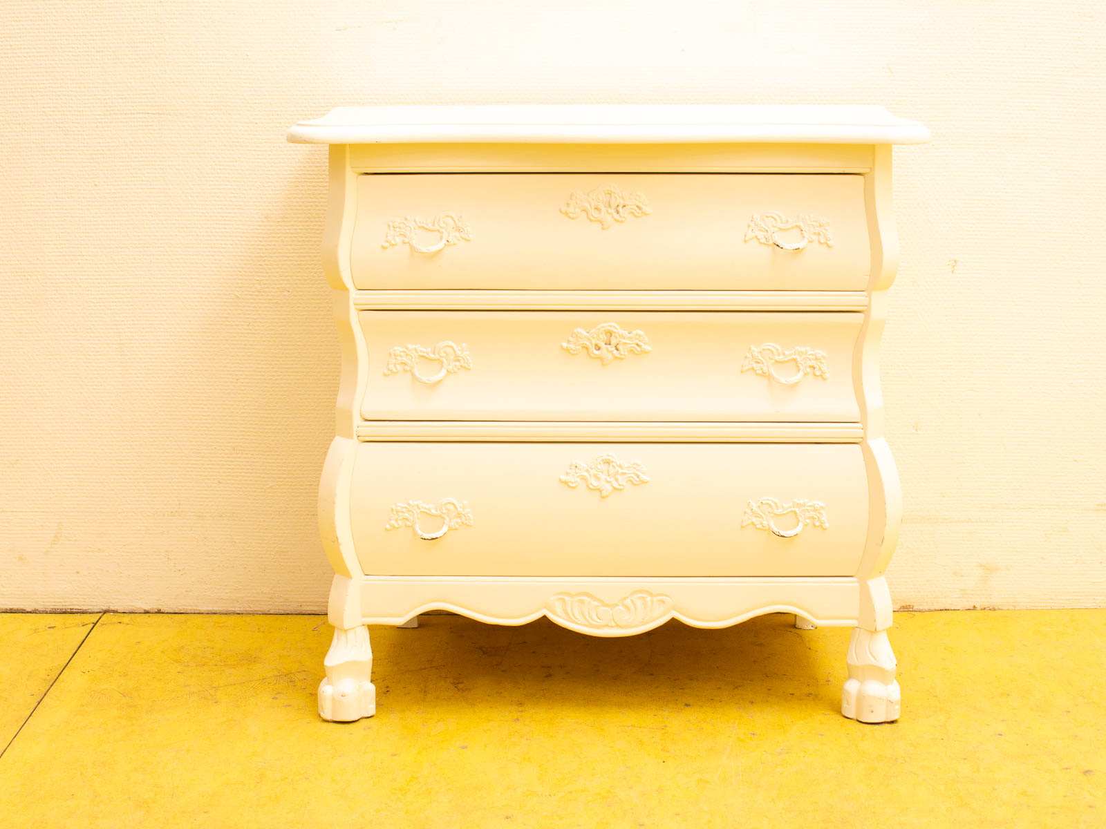 Elegant vintage white chest of drawers with claw feet and floral carvings for stylish storage.