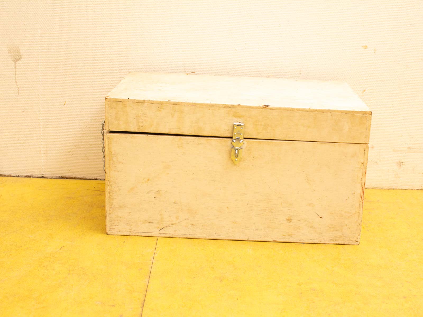 Vintage wooden box with latch on colorful floor, adding rustic charm and intrigue.