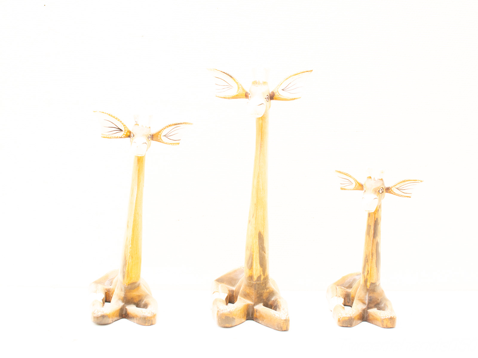 Charming trio of vintage wooden giraffe sculptures, perfect decor for animal lovers.