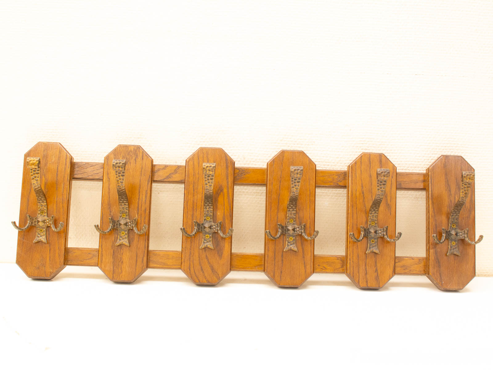 Elegant wooden coat rack with antique hooks, perfect for stylish entryways and mudrooms.