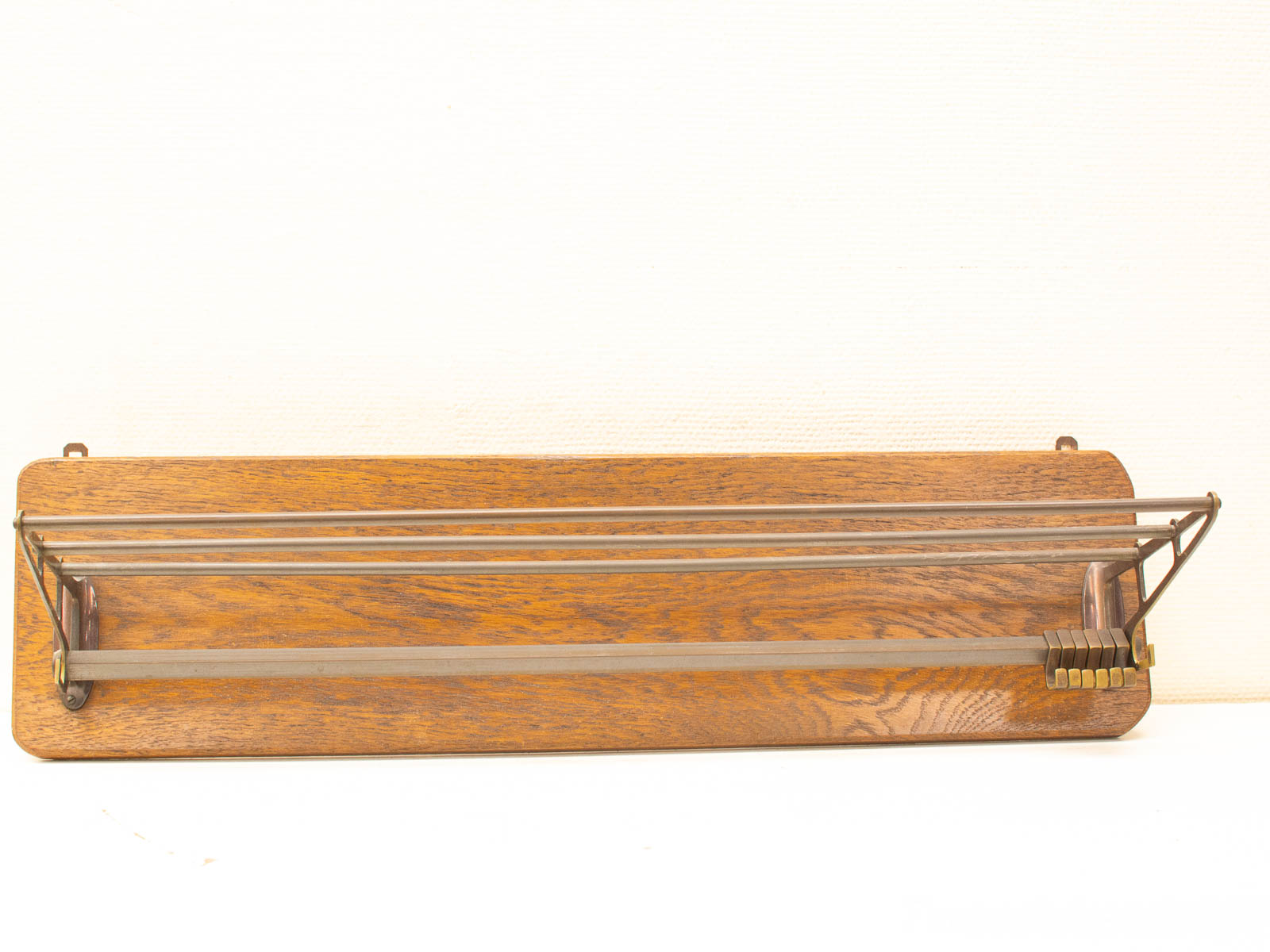 Elegant vintage wooden towel rack with metal accents and brass rollers for stylish home decor.