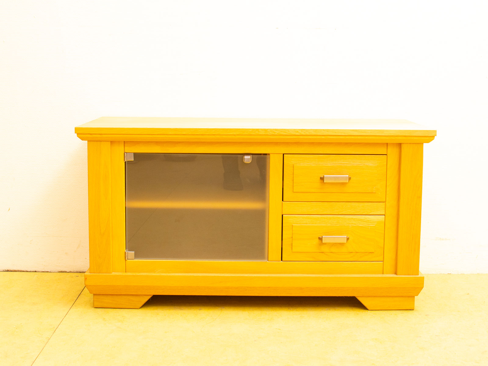 Modern wooden cabinet with glass panel, sleek design, and light yellow finish for stylish storage.