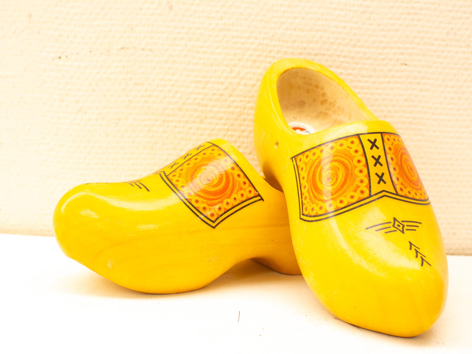 Vibrant yellow wooden clogs with intricate artistic designs celebrating Dutch cultural heritage.