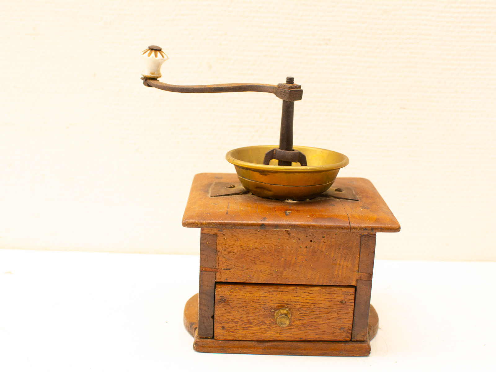 Vintage wooden coffee grinder with brass bowl, perfect for collectors and coffee enthusiasts.