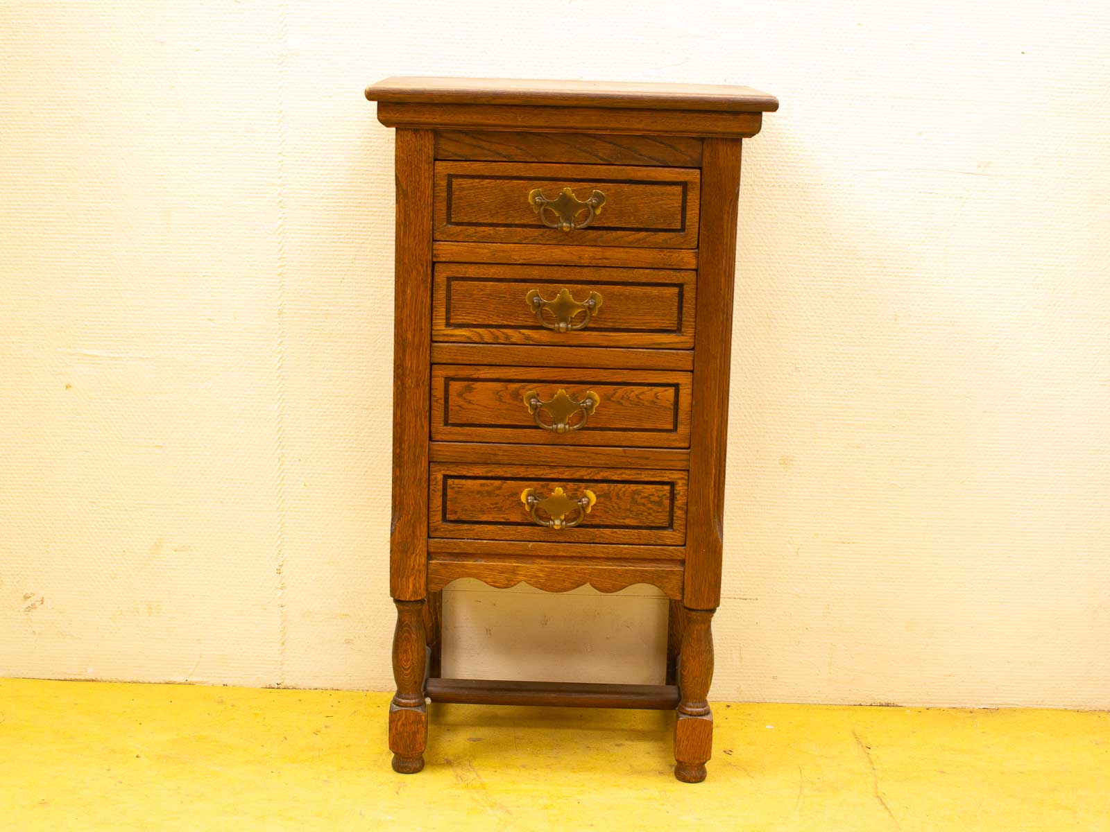 Charming vintage wooden chest of drawers with ornate brass handles and rustic elegance.