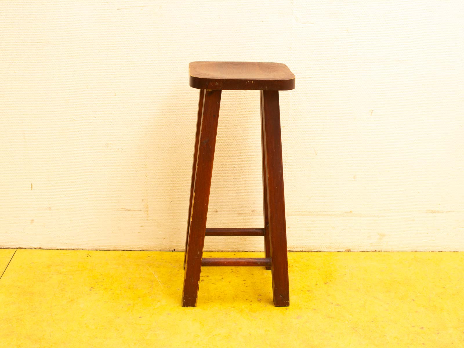 Charming minimalist wooden stool with rounded edges, tapered legs, and a warm brown finish.