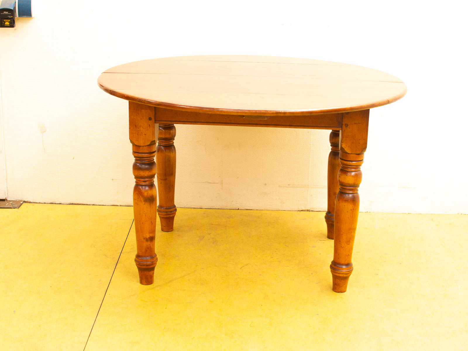 Elegant round wooden dining table with detailed legs, perfect for gatherings and timeless decor.